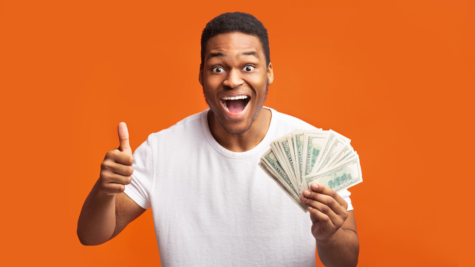 Happy black guy holding money on orange background